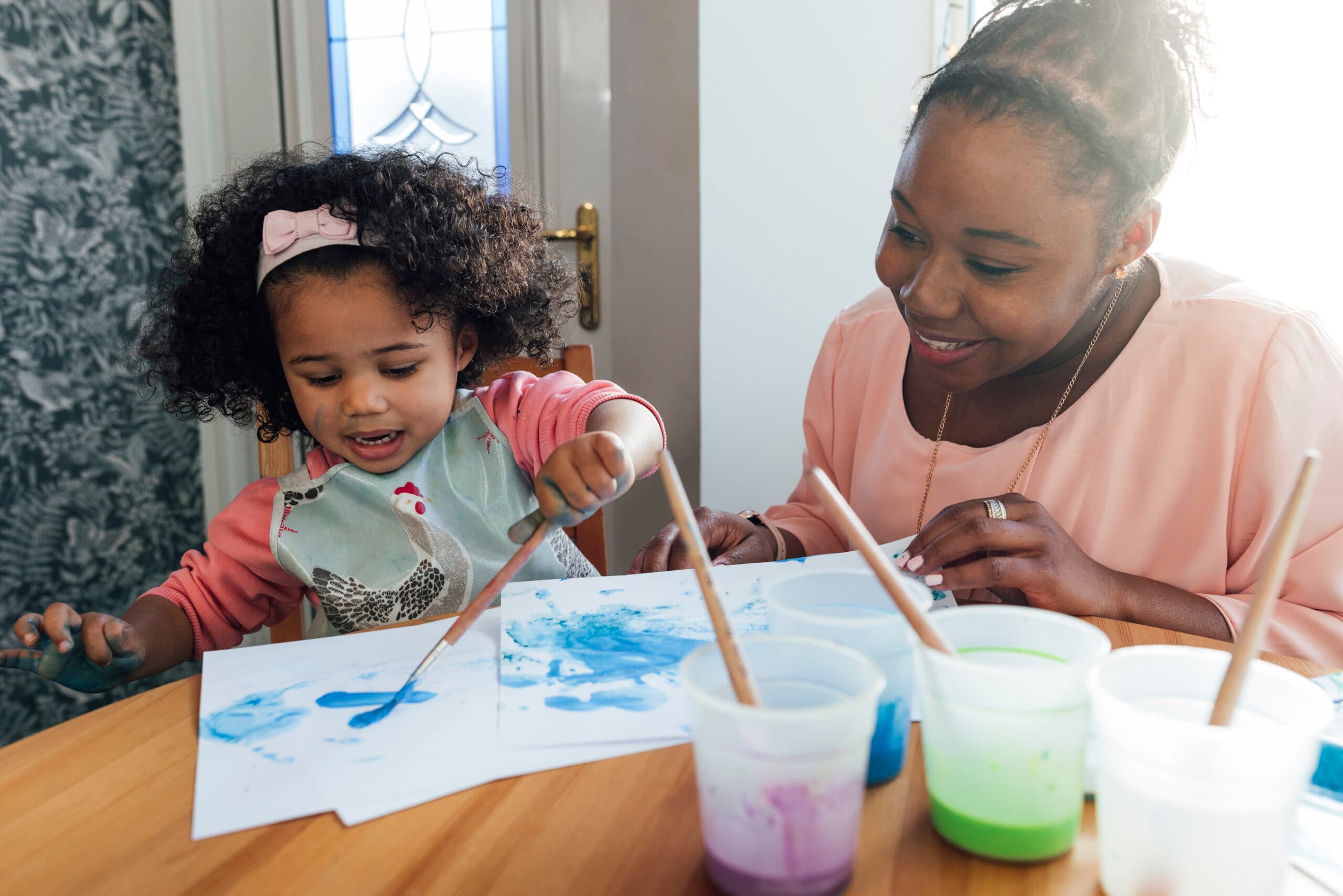 child painting with mom